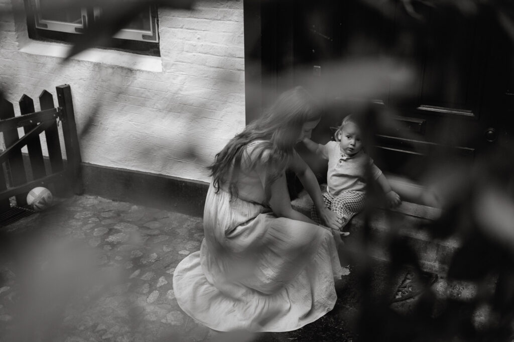 Familienfotografie in Hamburg mit Angie. Hier eine Mutter mit ihrem Kleinkind auf einer Treppe.