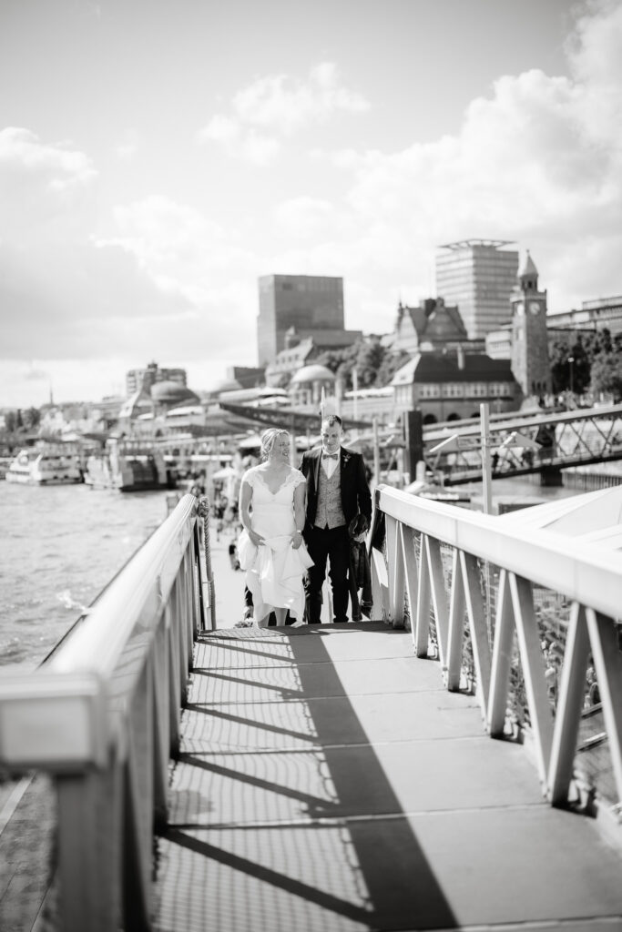 Am Hafen von Hamburg läuft das Brautpaar zur Kullisse. Angie Hochzeitsfotografin in Hamburg.