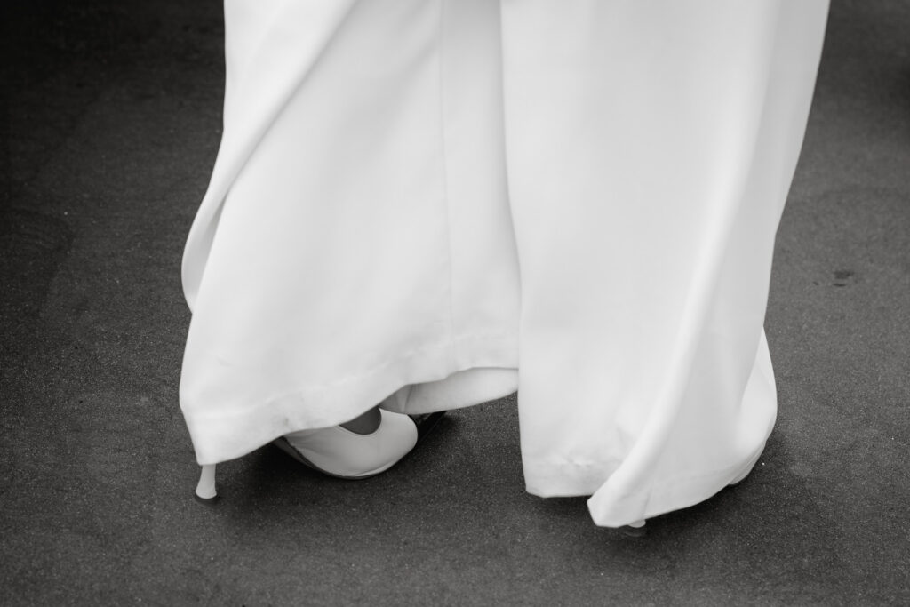 eure Hochzeit in Hamburg. Hier ein Schwarz-Weiß-Bild eines Brautkleides und weißen Schuhen